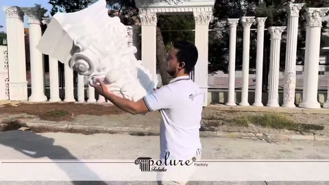 Staff member holding a large white column capital at chest height