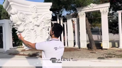 White decorative capital held at an angle to display its fine details