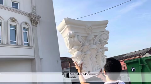 Pointed upper corner of a white ornamental capital shown in detail