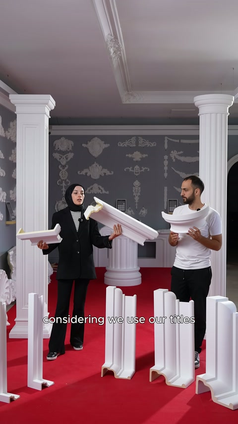 Commessi tengono reciprocamente due lunghi pezzi di cornice tra le colonne