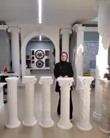 Tavolini a colonna e modelli di colonne decorative bianchi in poliuretano sono disposti nello showroom