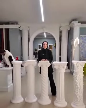 Colonne decorative bianche di varie altezze sono disposte lungo lo showroom