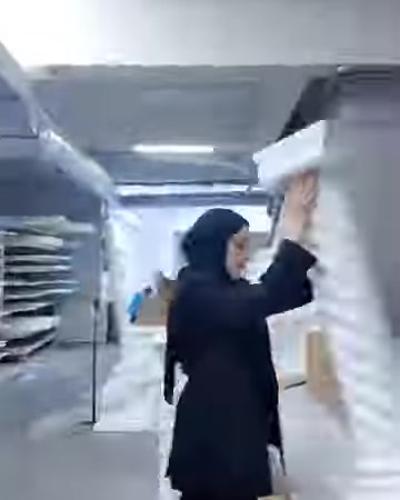 Un modello di colonna tortile lungo viene trasportato a mano nell'area produttiva