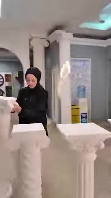 Sono esposti tavolini bianchi e colonne decorative di diverse altezze.