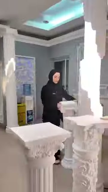L'addetto mostra i dettagli di una cornice quadrata in rilievo accanto al tavolino.
