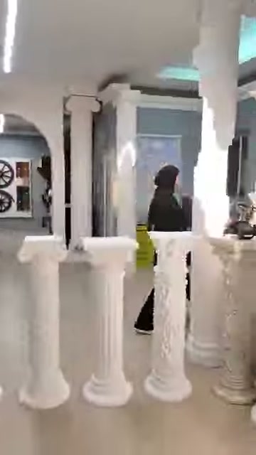 L'addetto indica la parte superiore della base decorata con motivi fogliari.