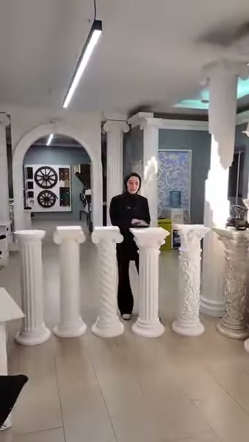 Basi bianche allineate in ampio showroom sono esposte insieme all'addetto.