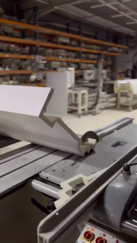 A long facade band molding is displayed on the cutting table with its side profile visible.