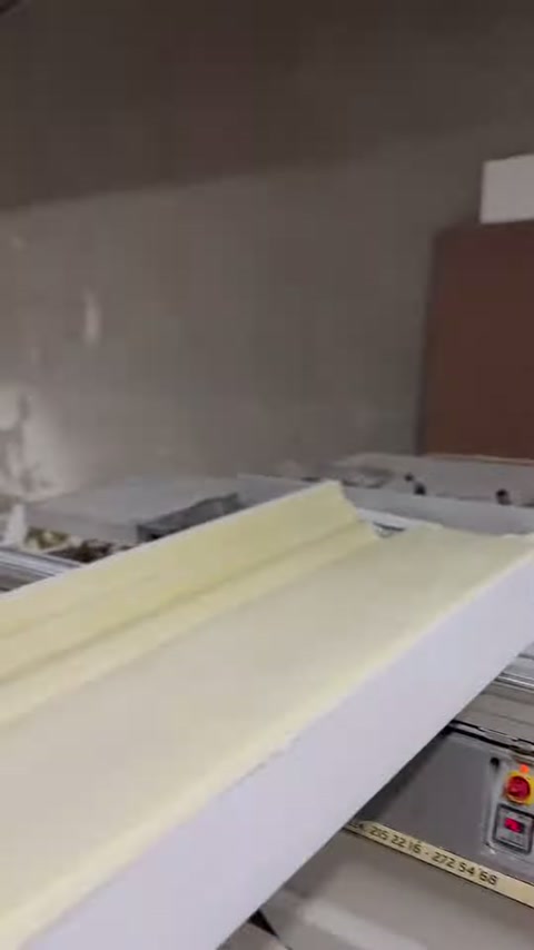 Wide cornice piece lies horizontally on the cutting table.