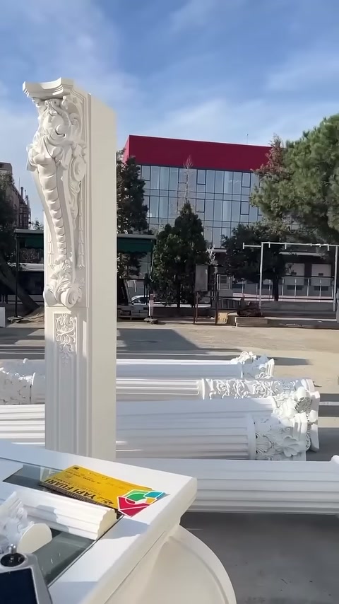 A long relief-decorated column element is visible in front of arranged models