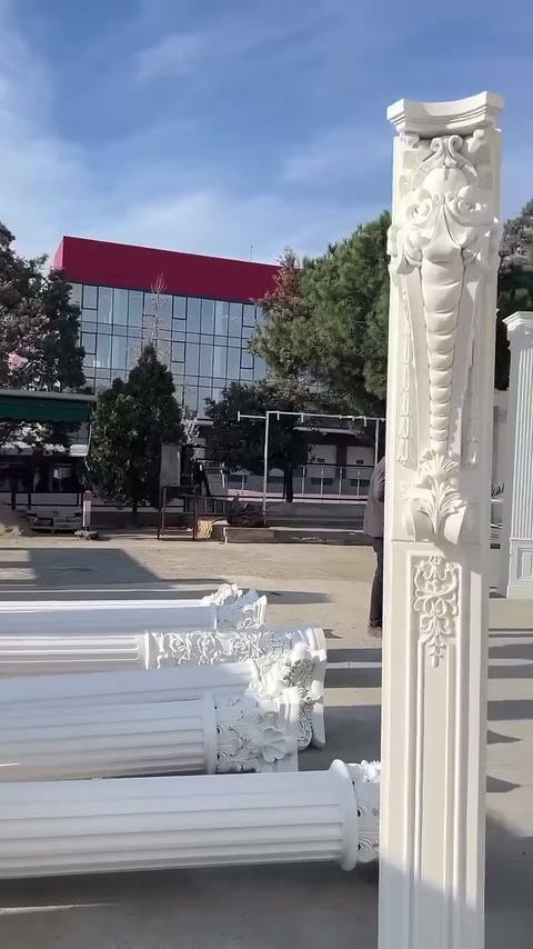 Fluted column shafts on the ground are lined up behind the vertical decorative piece