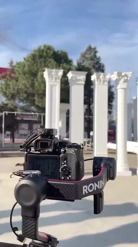 Different header-topped white column models are arranged behind the camera setup