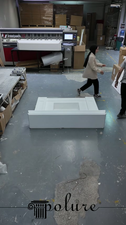 Elementi bianchi del camino vengono preparati sul pavimento del laboratorio in ordine di montaggio.