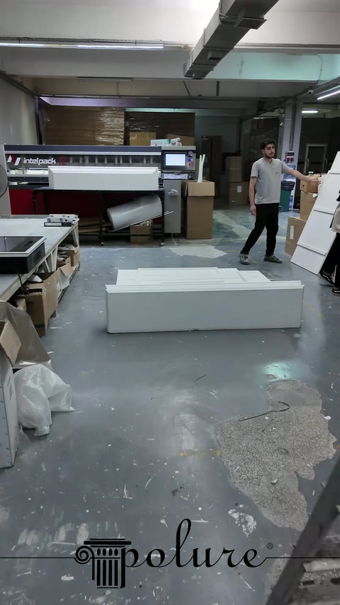 La cornice camino di produzione speciale viene allestita in laboratorio con i suoi ampi pannelli pronti per l'installazione.