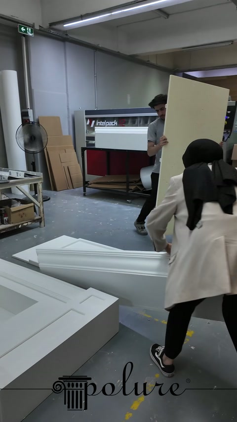 Il grande modulo camino bianco viene portato con cura nell'area di lavoro del laboratorio.