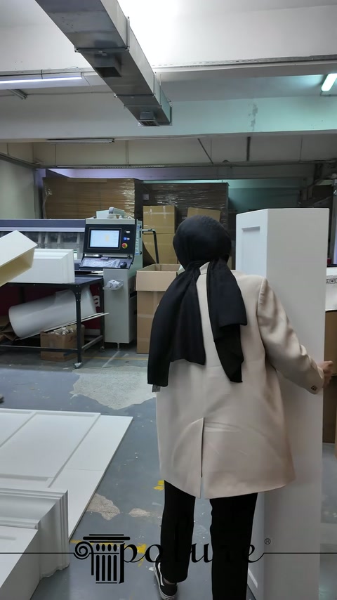 Il modulo laterale bianco tenuto in posizione verticale viene avvicinato al corpo camino in laboratorio.