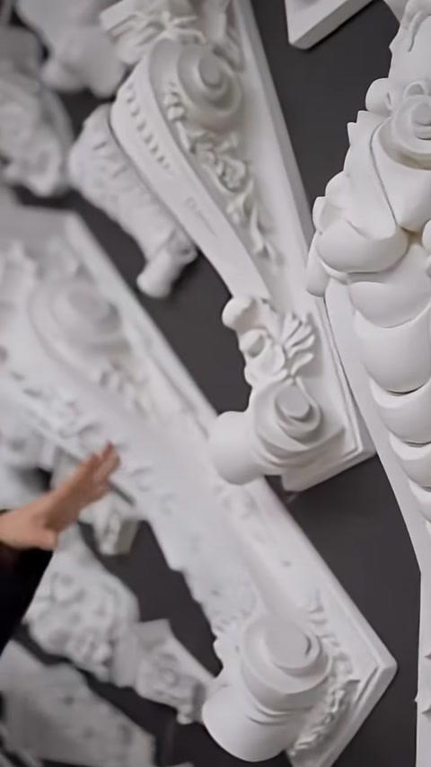 Raised details on the surface of a corbel with a curved leaf motif are shown