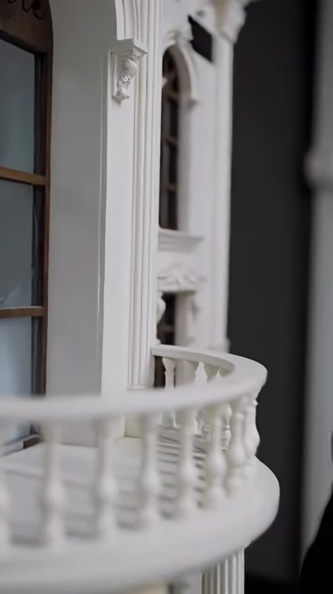 A model facade with a balcony railing and window surrounds is shown