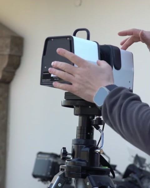 Technician scanning an architectural facade with handheld 3D scanner