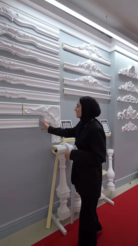 Gri duvarda profil şeritleri ve üçgen taç motifleri birlikte sunuluyor.
