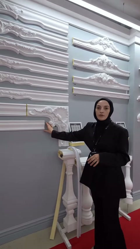 Sunucu duvardaki sivri tepeli dekoratif taç örneklerini işaret ediyor.