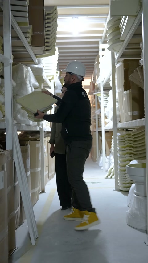 Worker lifts a curved ornamental profile element retrieved from the shelf
