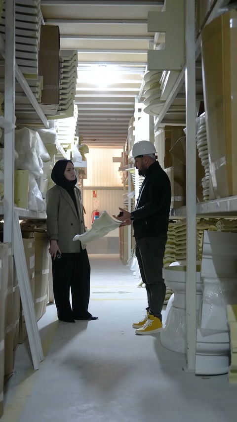 Long white decorative profile held horizontally between two workers