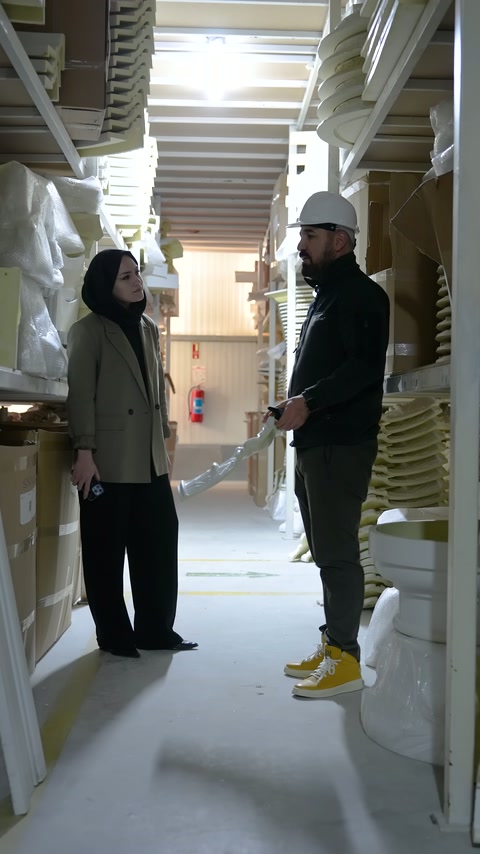 Worker points with his hand at decorative elements between the shelves