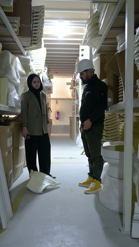 Two workers stand facing each other in front of polyurethane product shelves