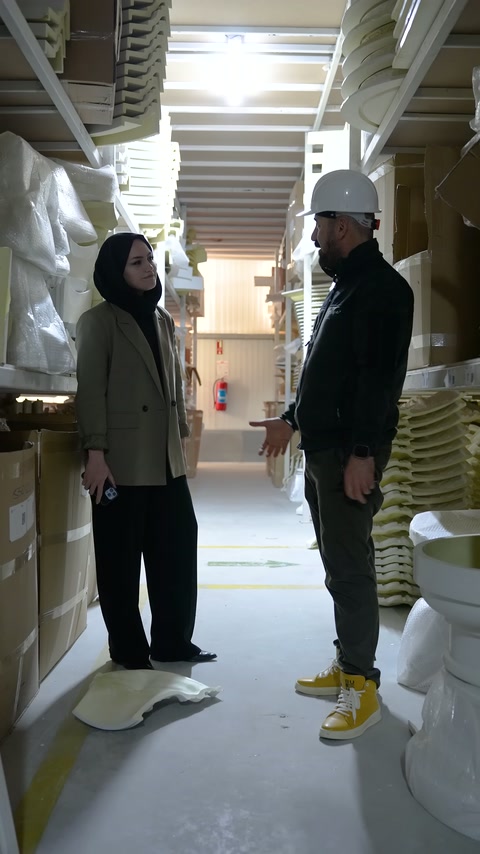 Two people jointly examine different ornamental elements on the shelves