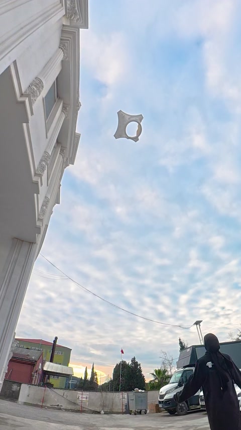 Dekoratif beyaz cephe parçası açık alanda havaya fırlatılıyor.