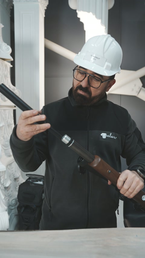 Uygulayıcı uzun namluyu kaldırıp uç kısmına yakından bakıyor.