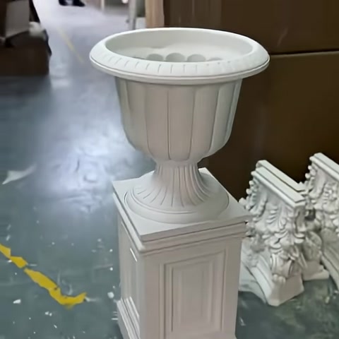 Fioriera decorativa di forma classica posizionata su base quadrata