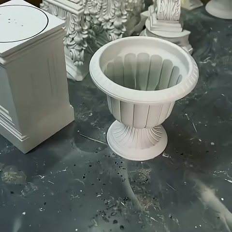 Poliüretan kaplamalı plastik dekoratif saksı, atölyede kaidesiyle birlikte sergileniyor.