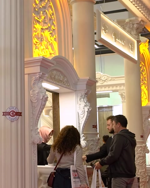 Visitatori esaminano il display di pilastro in poliuretano e cornice specchio