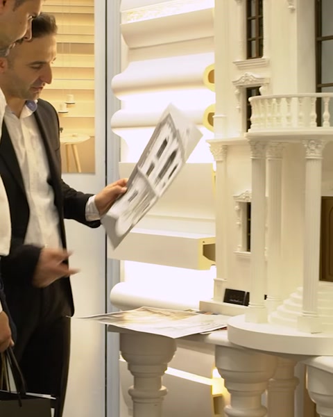 Uomo che tiene un pannello campione di cornice decorativa allo stand espositivo