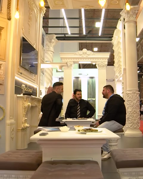 Membri dello staff seduti al tavolo riunioni all'interno dello stand espositivo