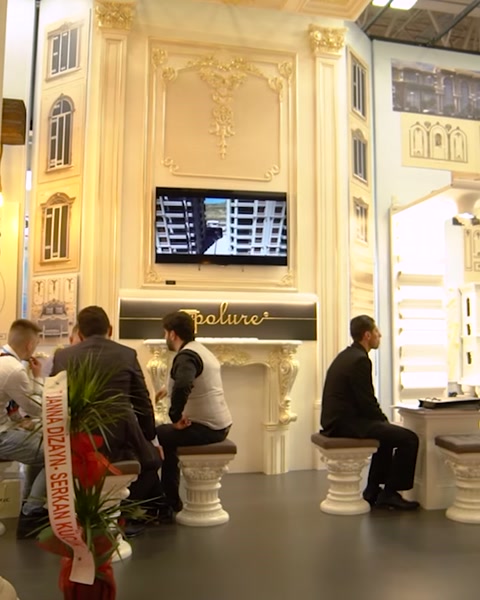 Televisione a parete mostra presentazione accanto a colonne decorative