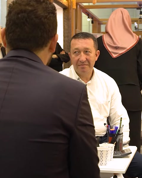 Tre colleghi seduti discutono affari al tavolo espositivo