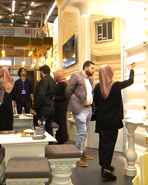 Gruppo di visitatori cammina attraverso la corsia dello stand espositivo decorato