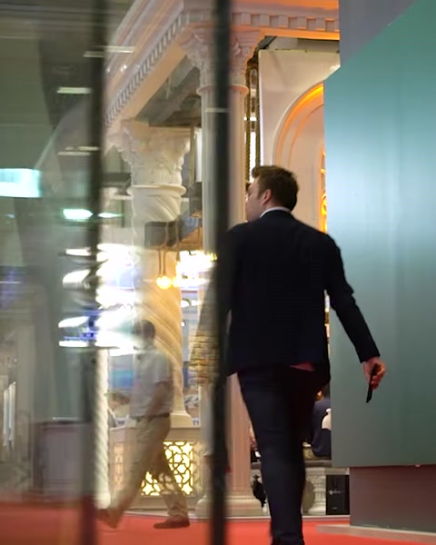 Uomo cammina accanto a un display di pannello in vetro illuminato