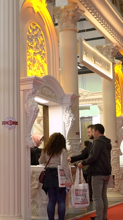Visitatori esaminano il display di pilastro in poliuretano e cornice specchio