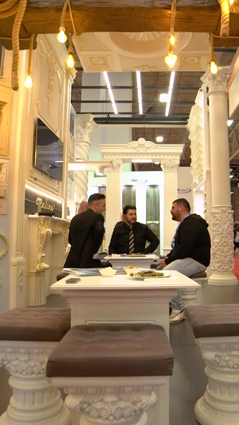 Membri dello staff seduti al tavolo riunioni all'interno dello stand espositivo