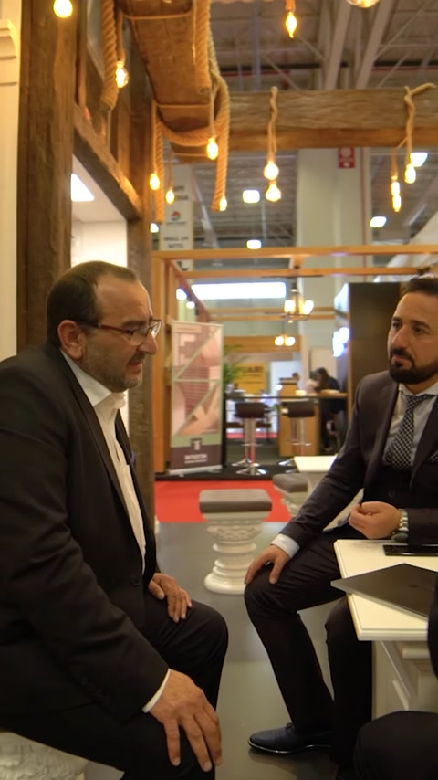 Uomini d'affari discutono campioni di prodotti allo stand espositivo Polure