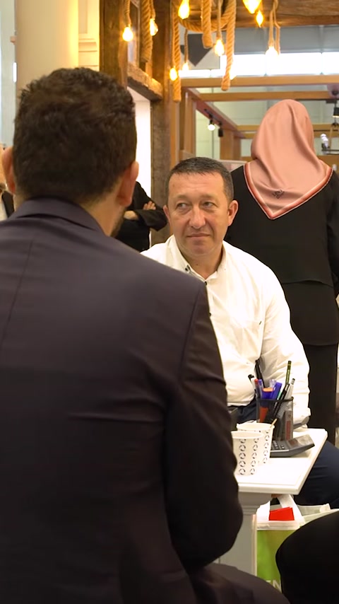 Tre colleghi seduti discutono affari al tavolo espositivo
