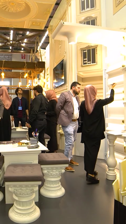 Gruppo di visitatori cammina attraverso la corsia dello stand espositivo decorato