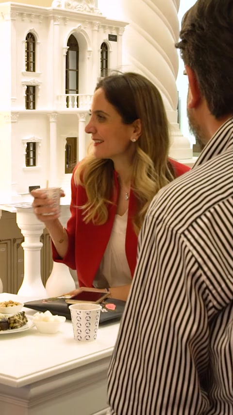 Donna che beve caffè accanto a un piedistallo di colonna in poliuretano ornato
