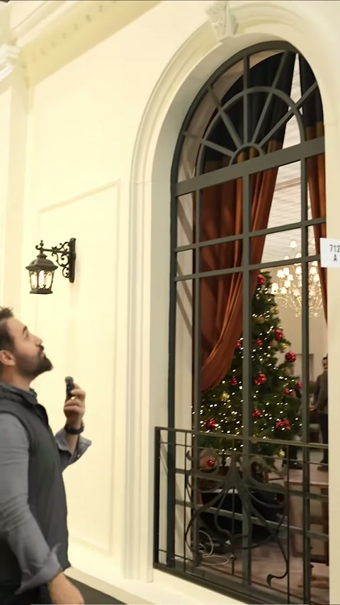 Si vedono finestra ad arco, applique decorativo e pannelli murali incorniciati