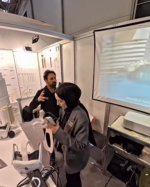 Un uomo e una donna provano un visore per la realtà virtuale vicino all’esposizione di prodotti architettonici