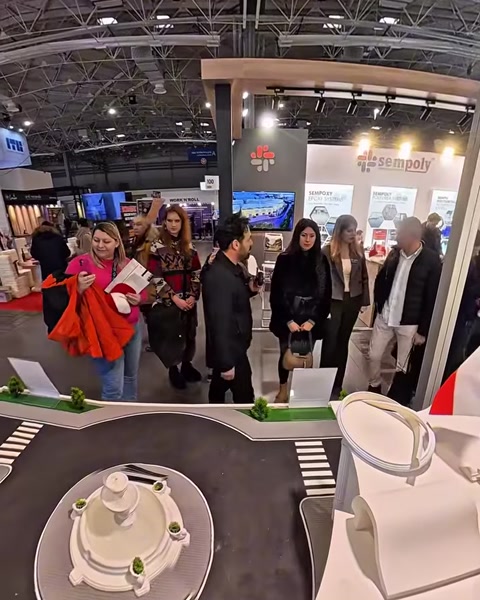 Folla di visitatori che attraversa il padiglione espositivo vicino all’ingresso dello stand
